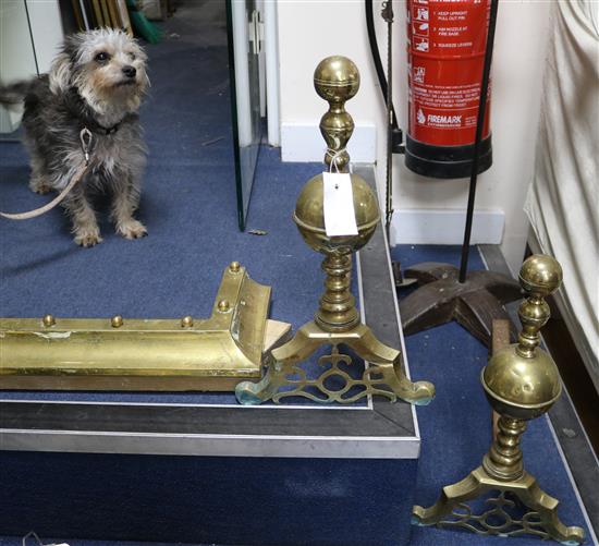 A pair of brass fire dogs and a kerb